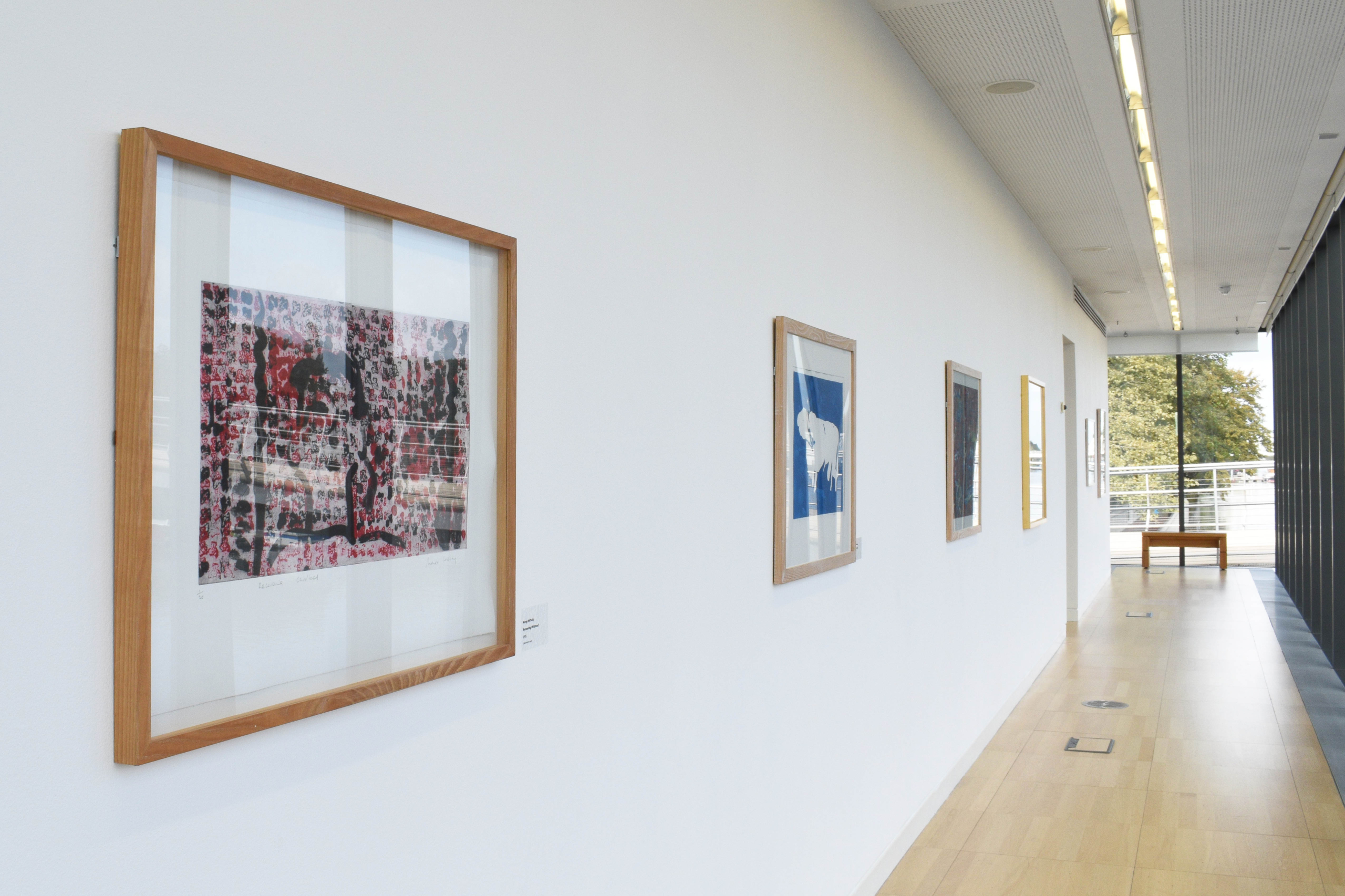 Art on a white wall in a hallway at the exhibition Symbols of Subject at Luan Gallery
