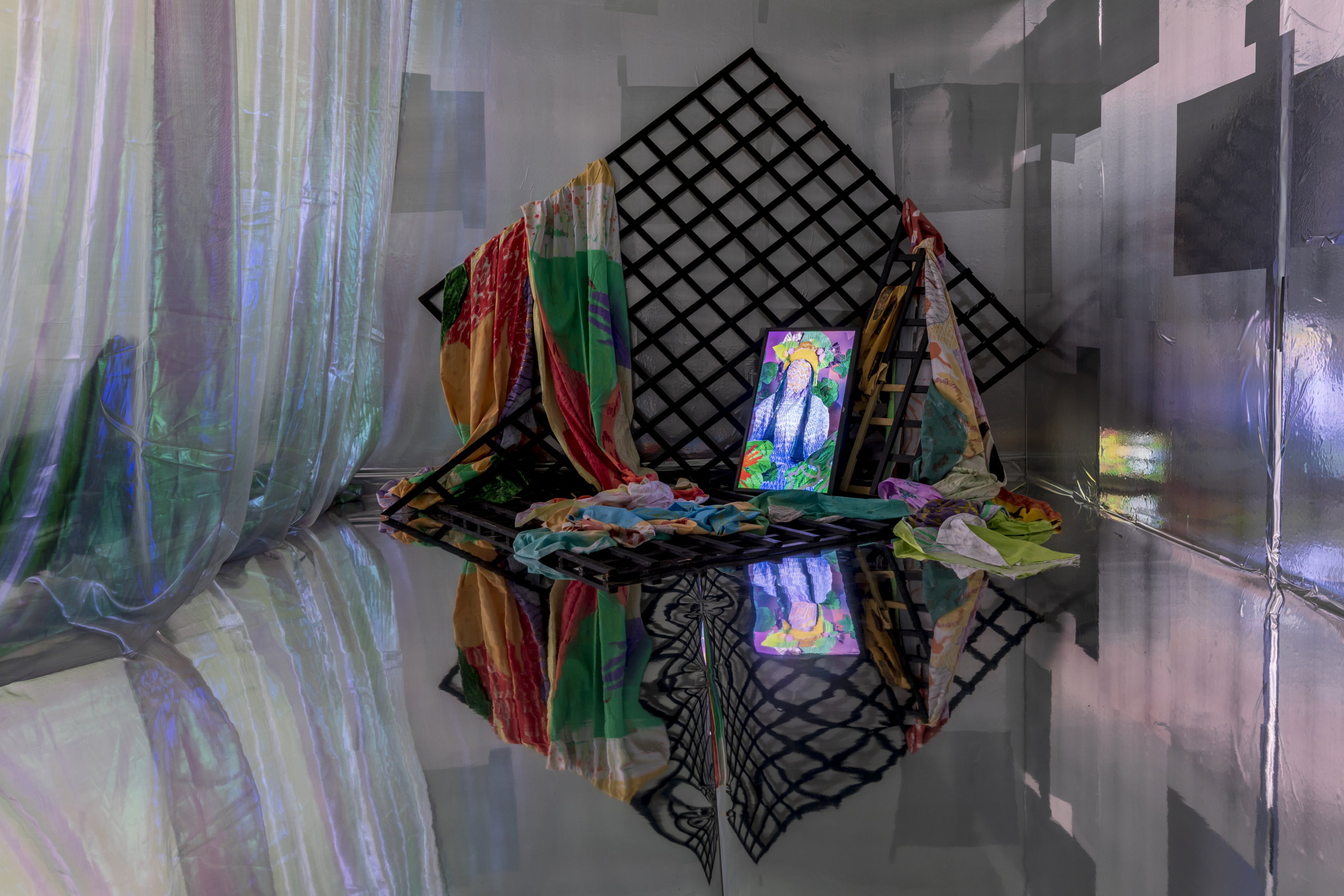 Colourful installation on the floor with a mirror-like background and floor at the exhibition Portals at Luan Gallery