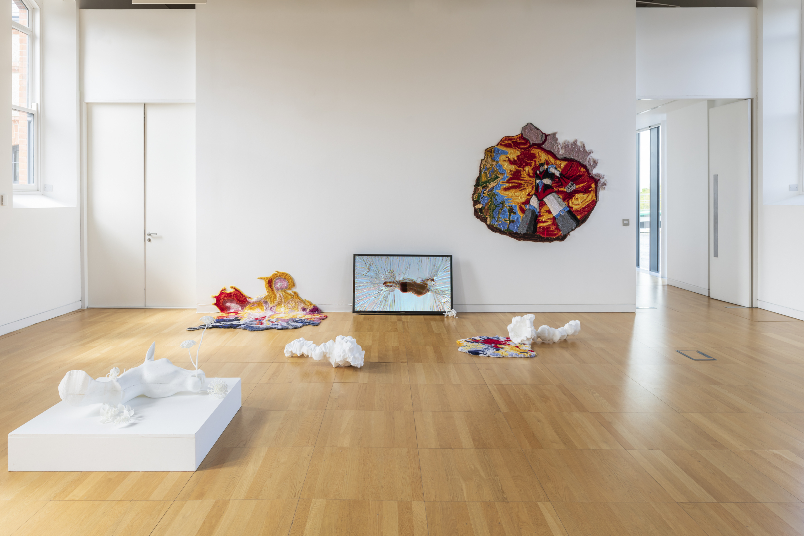 Colourful art on the wall and a white installation on the floor at the exhibition Portals at Luan Gallery