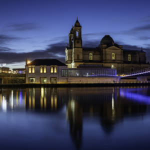 Luan Gallery Gift Voucher - The Gallery at night lighted up, mirroring in the water with a bridge next to