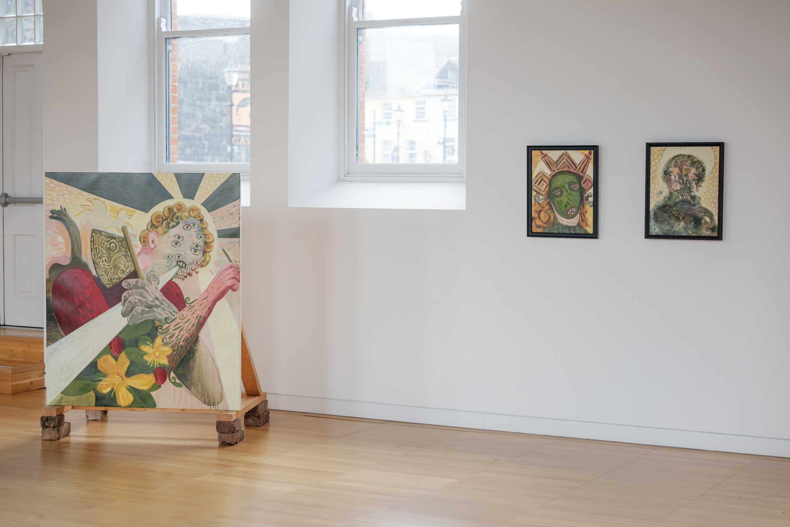 Art on floor and art next to window at the exhibition Tuberclerosies at Luan Gallery