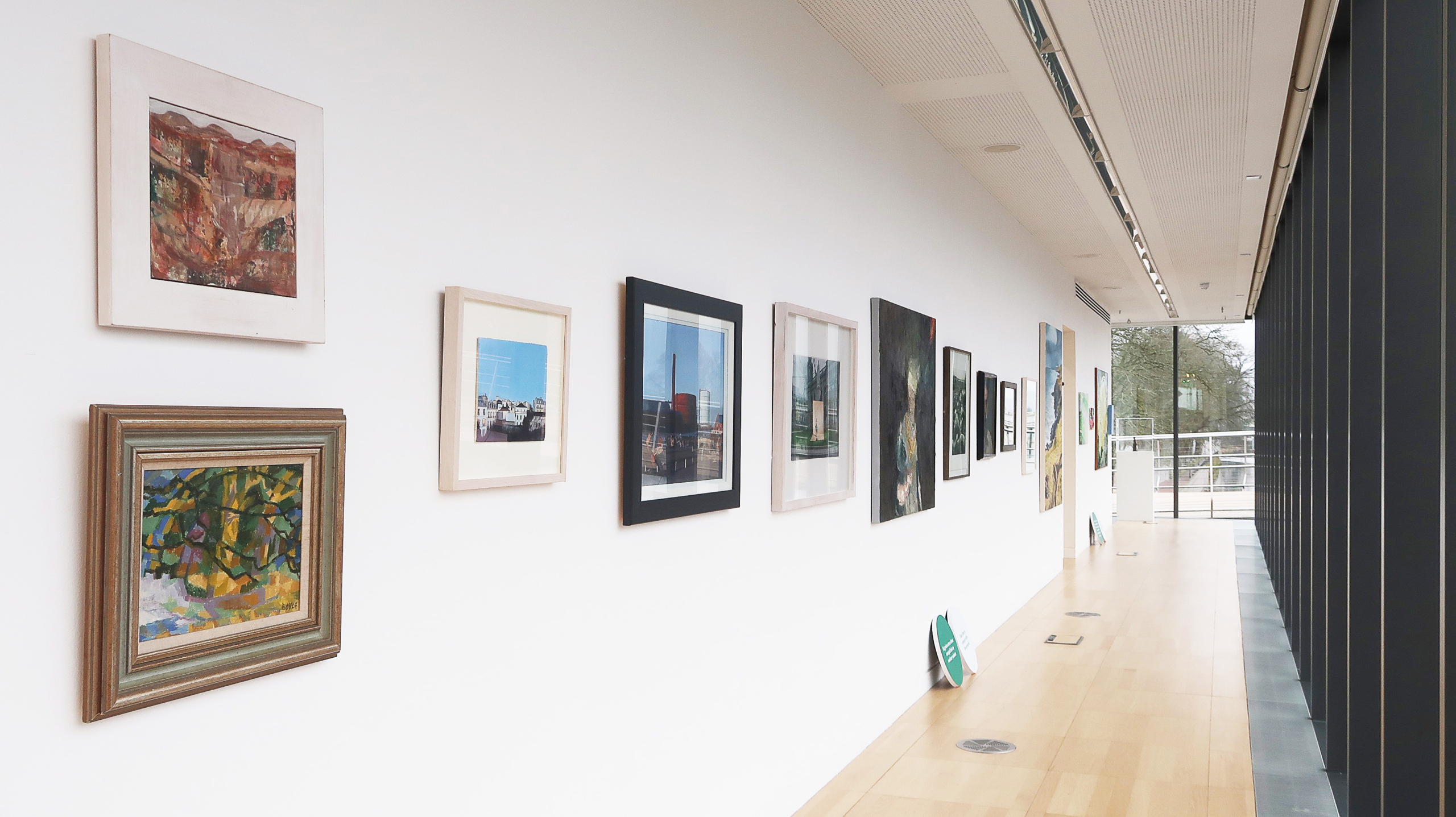 Exhibition Connections, Art on white wall in hallway at Luan Gallery