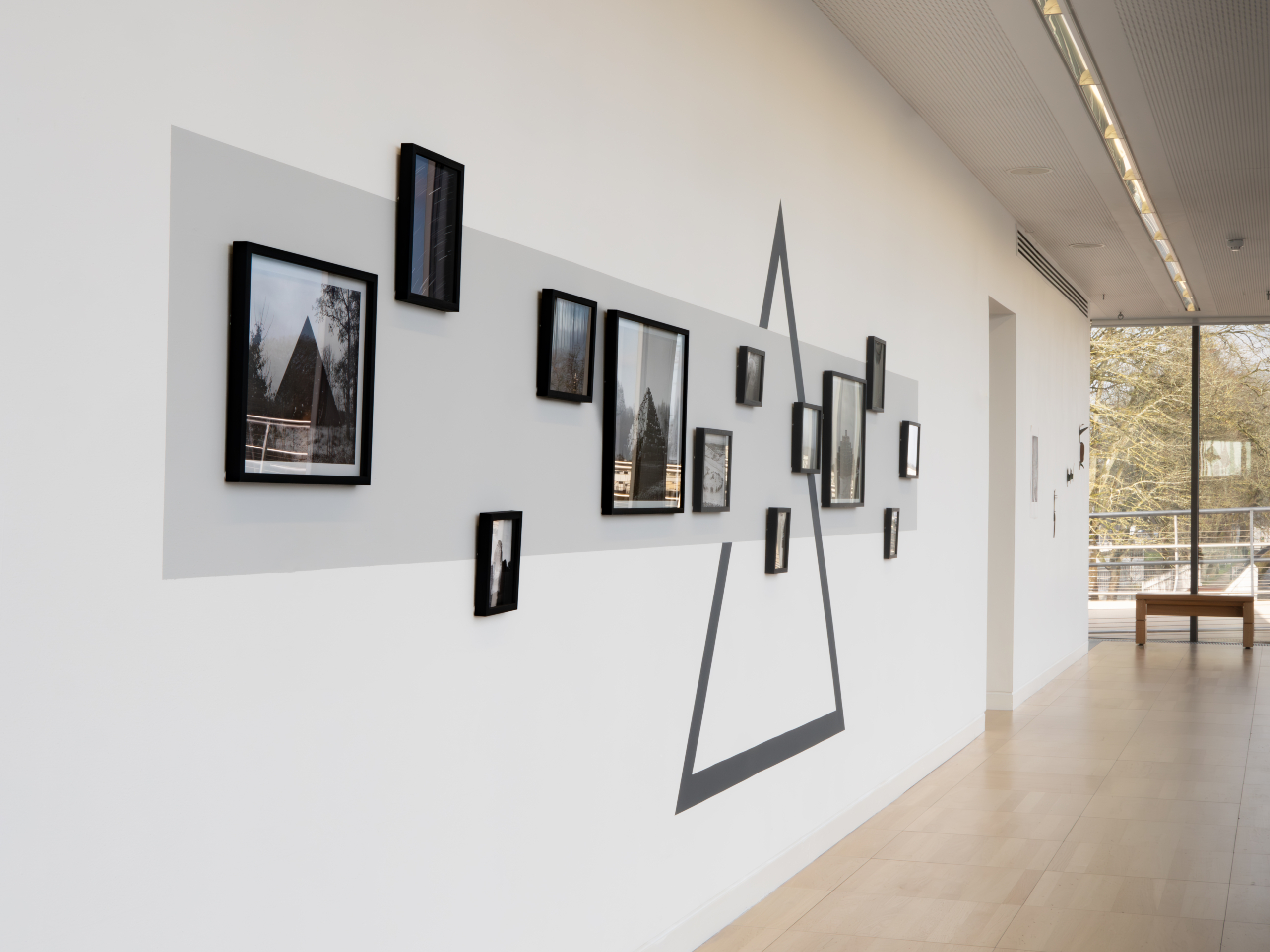 Black-framed artwork on a white and grey wall at the Take Care to Leave a Trace exhibition, Luan Gallery