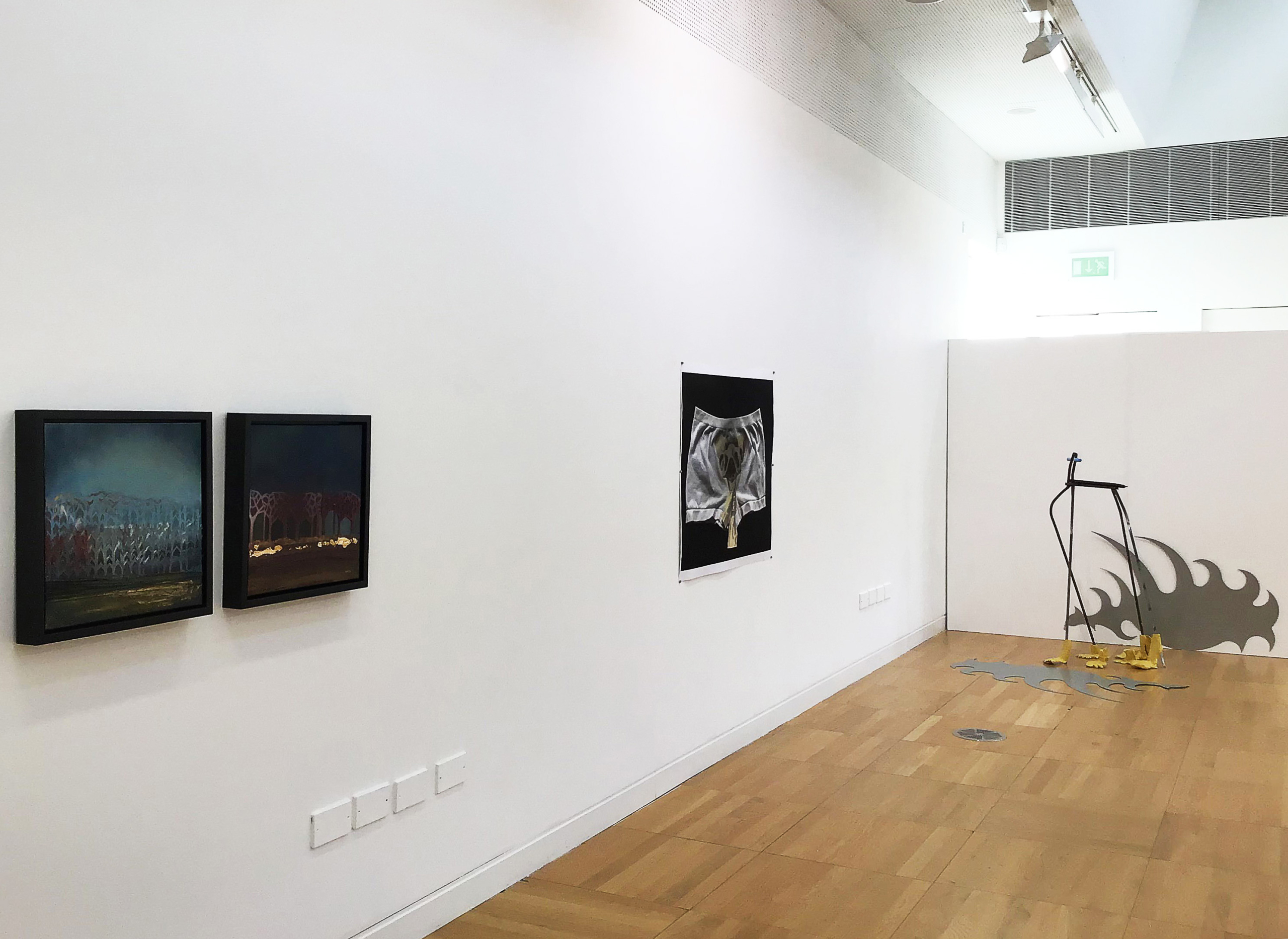 art on a white wall and a sculpture on the wooden floor at Luan Gallery