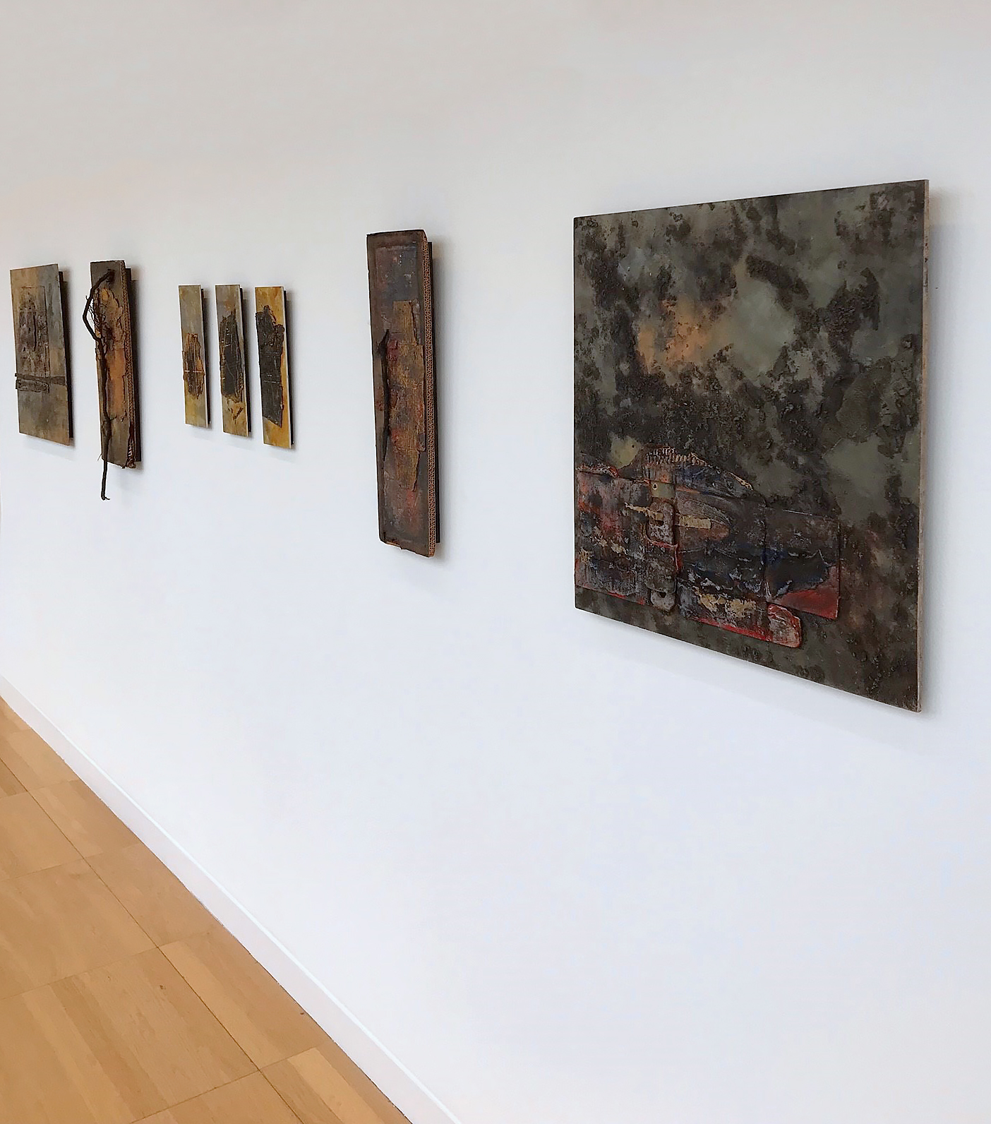 Rosemarie Langtry exhibition at Luan Gallery - 7 art pieces in dark colors on a white wall